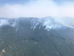 An aerial view of Koch Mountain Ridge on August 14, 2022. Smoke from the Cedar Creek Fire is seen rising in the terrain below.
