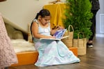 A young girl reads a book from the reading nook underneath the stairs of khwat yaka haws on June 25, 2024.