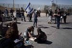 People gather at Israel's Nitzana border crossing with Egypt in southern Israel on Tuesday, March 5, protesting against the delivery of humanitarian aid to the Gaza Strip until all of the hostages being held by Hamas have been released.