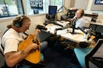 Walsh conducts an interview with musician Matt Fockler, as he plays an acoustic guitar.