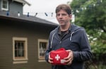 John Stephens takes his first aid kit out to have on hand during the earthquake simulation at their home in North Portland.