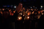 People wave their hands in prayer during a candlelight vigil at Drake Park after three children and a teacher were killed in a shooting at Silver Rail Elementary School in Bend, Ore. on Oct. 15, 2026. The suspected shooter was a 16-year-old who entered the school and was killed by an armed bystander, bringing the total number of deaths to five.