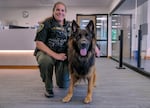 Multnomah County Sheriff's Deputy Kerri Oman poses with Burton, the agency's first comfort dog, at OPB before an appearance on "Think Out Loud" on June 7, 2024. Burton helps comfort victims of trauma and law enforcement personnel as part of a peer support program within the department.