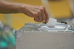 A voter casts a ballot in the upper house elections at a polling station Sunday, July 20, 2025, in Tokyo. (AP Photo/Eugene Hoshiko)