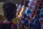 A young girl holds an adult's hand while lighting a candle in honor of victims of the Charleston, South Carolina shooting.