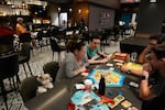 The Segundo family, who evacuated from nearby Davis Island, plays a board game with their dog Cassie looking on, as Hurricane Milton makes landfall on Florida's Gulf Coast, at Hyatt Place Tampa Downtown hotel in Tampa, Fla., Wednesday, Oct. 9, 2024.