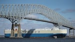 An outbound cargo ship passes under the Francis Scott Key Bridge in Baltimore in 2018. A cargo vessel slammed into the steel-truss bridge on March 26 of this year, causing it to collapse.