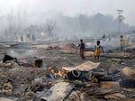 Rohingya refugee boys salvage a gas cylinder after a major fire in the Balukhali camp in Bangladesh.