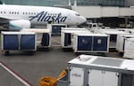 In this Feb. 25, 2019, file photo, baggage from an Alaska Airlines flight is unloaded at Portland International Airport in Portland, Ore.