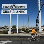 The silhouette AR-15-style rifle is displayed on signage for the Firearms Unknown Guns & Ammo gun store in Yuma, Ariz., last week.