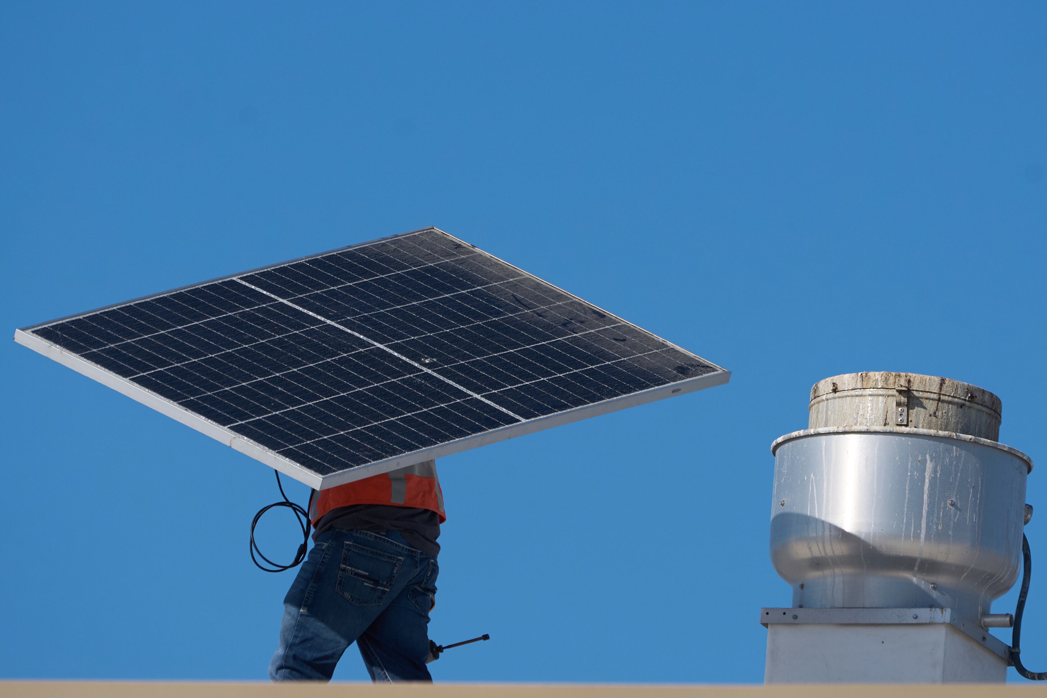 A worker carries a solar panel on the roof of the Alta Sea building, an urban, ocean-based research and blue technology innovation campus, at Berth 58 in the Port of Los Angeles on Thursday, Sept. 4, 2025.