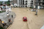 Pedestrians and vehicles navigate flooded roads after heavy monsoon rains in Mingora, in the Swat Valley, on Aug. 27.