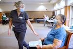 Michelle Townley, RN, left, talks with Alice Maurer, 79, while Maurer waits 15 minutes after receiving her COVID-19 vaccination. Alice Maurer is hoping to be able to visit her husband Nick after she’s fully vaccinated.