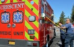 Crescent Fire volunteer Chris Jones (far right) washes an ambulance on May 30, 2025. Jones retired last year after 25 years as a firefighter and paramedic in La Pine. He says calls for help have increased past what rural agencies can handle.