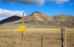 A sign warns people to travel at their own risk, as clouds cast shadows over the Cow Valley in far Eastern Oregon on Nov. 17, 2021.