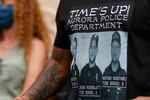 FILE - In this July 3, 2020, file photo, Terrance Roberts, front, wears a shirt bearing photographs of Aurora, Colo., police Department officers involved in the stop of 23-year-old Elijah McClain at the memorial site across the street from where the young man was stopped by while walking home at a news conference in Aurora, Colo. Colorado’s attorney general said Wednesday, Sept. 1, 2021 that a grand jury indicted three officers and two paramedics in the death of Elijah McClain, a Black man who was put in a chokehold and injected with a powerful sedative two years ago in suburban Denver.