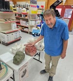 Whit Deschner, the founder of the Great Salt Lick auction, poses with salt licks at the Oregon Trail Livestock Supply store in Baker City, Ore., on Sep. 12, 2024, in this provided photo. The salt licks will be auctioned off at at the annual auction event in Baker City which has raised more than $212,000 for Parkinson's disease research since it started in 2006.