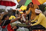 Shahu Patole, 63, buys vegetables in an open air market in Khamgaon, India on November 11, 2024. Maya Levin for NPR