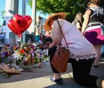 A woman kneels at a memorial for the victims of the MAX stabbing.