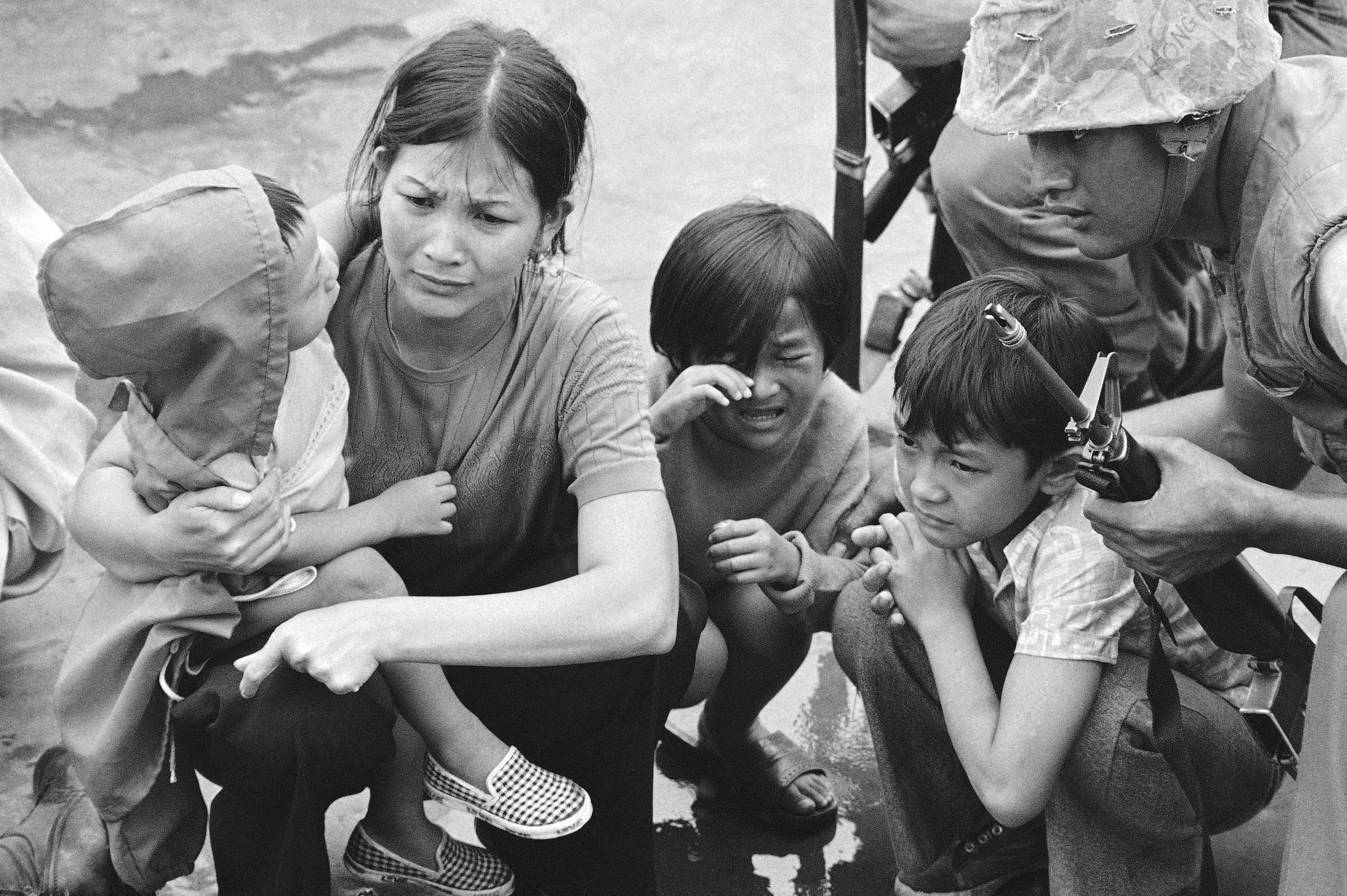 A South Vietnamese mother and her three children on the deck of an amphibious command ship being plucked out of Saigon by U.S. Marine helicopters on April 29, 1975.