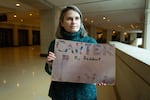 Susan Prolman, 59, holds up a sign from when she campaigned for President Jimmy Carter as a child growing up in New Hampshire. She remembers him coming to stay with her family during a campaign visit. Prolman visited the flag-draped casket of former President Jimmy Carter lying in state in the U.S. Capitol in Washington, D.C., on Jan. 8.