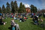 Eclipse watchers fill the lawn at Observatory Park, near the University of Denver, as the sun is partially blocked by the moon. April 8, 2024.