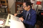 Cartoonist T. Edward Bak works on his art in his St. Johns basement, “This statue is so meaningful for the continuum of people who gather to express their First Amendment rights,” Bak said. Portland, March 30, 2026