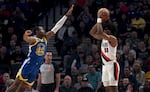 Portland Trail Blazers guard Scoot Henderson, right, shoots over Golden State Warriors forward Jonathan Kuminga, left, during the first half of an NBA basketball game in Portland, Ore., Thursday, April 11, 2024.