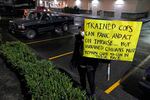 A person holds a sign during a protest against police brutality, late Sunday, Jan. 24, 2021, in downtown Tacoma, Wash., south of Seattle.