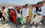 A man holds a certificate acknowledging his work for Americans as hundreds of people gather outside the international airport in Kabul, Afghanistan, Tuesday, Aug. 17, 2021. The Taliban declared an “amnesty” across Afghanistan and urged women to join their government Tuesday, seeking to convince a wary population that they have changed a day after deadly chaos gripped the main airport as desperate crowds tried to flee the country. (AP Photo)