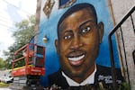 A painted mural of a smiling Black man.