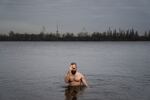 Nikolai Pastuchenko crosses himself as he dips in the river in Dnipro as part of a tradition for the Eastern Christian holiday the Epiphany in January.