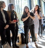 Lis Charman, center, and Patricia Parsons, right, applaud during a press conference at the Jordan Schnitzer Museum of Art, in Portland, April 2, 2024. Charman is the director of the current School of Art + Design at PSU. 