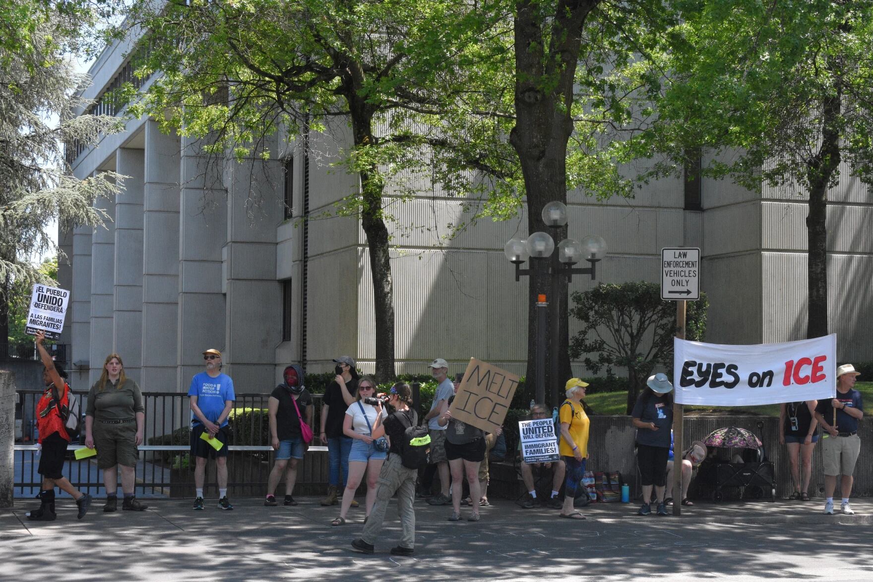 Protestors stand outside of the gates of the parking area at the federal courthouse in Eugene, July 8, 2025.