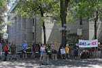 Protestors stand outside of the gates of the parking area at the federal courthouse in Eugene, July 8, 2025.