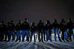 Federal immigration officers confront protesters outside Bishop Henry Whipple Federal Building, Jan. 15, 2026, in Minneapolis.