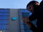 People walk outside Twitter headquarters in San Francisco, Friday, Nov. 4, 2022.