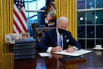 President Joe Biden signs his first executive order in the Oval Office of the White House on Wednesday, Jan. 20, 2021, in Washington.