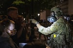 Protesters demonstrate against racism and police violence in front of the Mark O. Hatfield federal courthouse. Earlier in the night, federal law enforcement officers shot a demonstrator in the head with a less-lethal impact munition, causing severe injury.