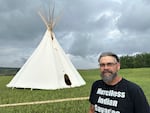 Jamie Azure, chair of the Turtle Mountain Band of Chippewa Indians, stands near a tepee outside the Turtle Mountain Recovery Center on the tribal nation’s reservation in Belcourt, N.D., in July.