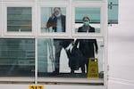Peter Ben Embarek and Thea Koelsen Fischer of the World Health Organization team prepares to board a plane from the tarmac at the airport to leave at the end of the WHO mission in Wuhan, China, Wednesday, Feb. 10, 2021.