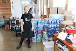 Shannon Chasteen stands in front of donated bottles of water that the Blanchet House distributes every day to help Portlanders beat the heat.