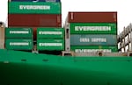 Shipping containers, most of which are green and say "Evergreen" in white letters on them, are stacked on a container ship docked at the Port of Los Angeles in California on May 6, 2025.