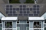 In an aerial view, solar panels are seen on the roof of an apartment complex.