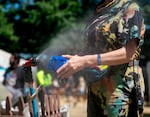 A crew member wets a rag in a mist stream at the Waterfront Blues Festival in downtown Portland, Ore., July 6, 2024. In response to the heat wave, the festival set up free misting and water bottle filling stations. 