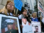 Kathleen Scarpone, left, of Kingston, N.H., and Cheryl Juaire, second from left, of Marlborough, Mass., protest in front of the Arthur M. Sackler Museum, at Harvard University, April 12, 2019, in Cambridge, Mass. Scarpone, who lost her son to OxyContin addiction, and Juarie addressed three Sackler family members during a virtual U.S. Bankruptcy Court hearing, Thursday, March 10, 2022.