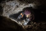 A zama-zama uses a jackhammer to break up rock in an abandoned De Beers mine.