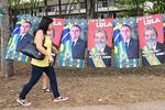 A woman walks past towels with the images of former Brazilian President (2003-2010) and presidential candidate for the leftist Workers Party (PT), Luiz Inacio Lula da Silva, and Brazilian President and re-election candidate Jair Bolsonaro on the street in Brasilia, Brazil, on Oct. 21.