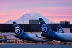 FILE - Alaska Airlines planes are parked at gates with Mount Rainier in the background at sunrise, on March 1, 2021, at Seattle-Tacoma International Airport in Seattle.