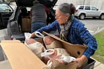 Julie Miller helps deliver frozen turkeys ahead of Thanksgiving. She is one of several volunteers helping the ABCD Allston/Brighton Neighborhood Opportunity Center in Boston. Demand there has spiked since SNAP benefits have lapsed, and some people looking for food assistance have to wait two weeks for help.